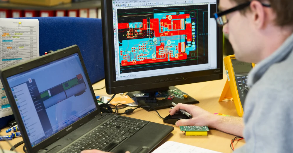 An engineer looking at CAD designs on a computer screen